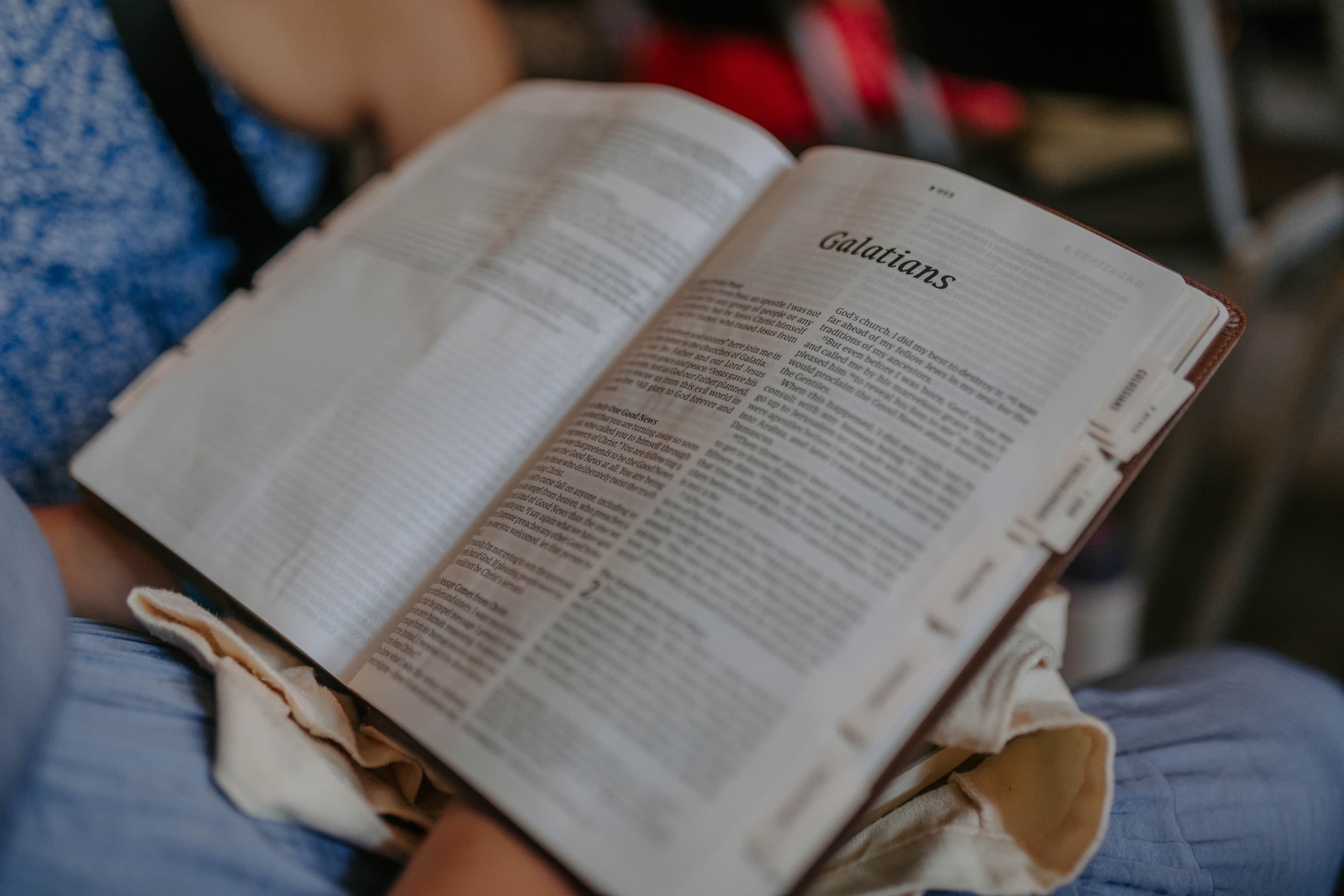 An open Bible on someone's lap during Elevate Bible study