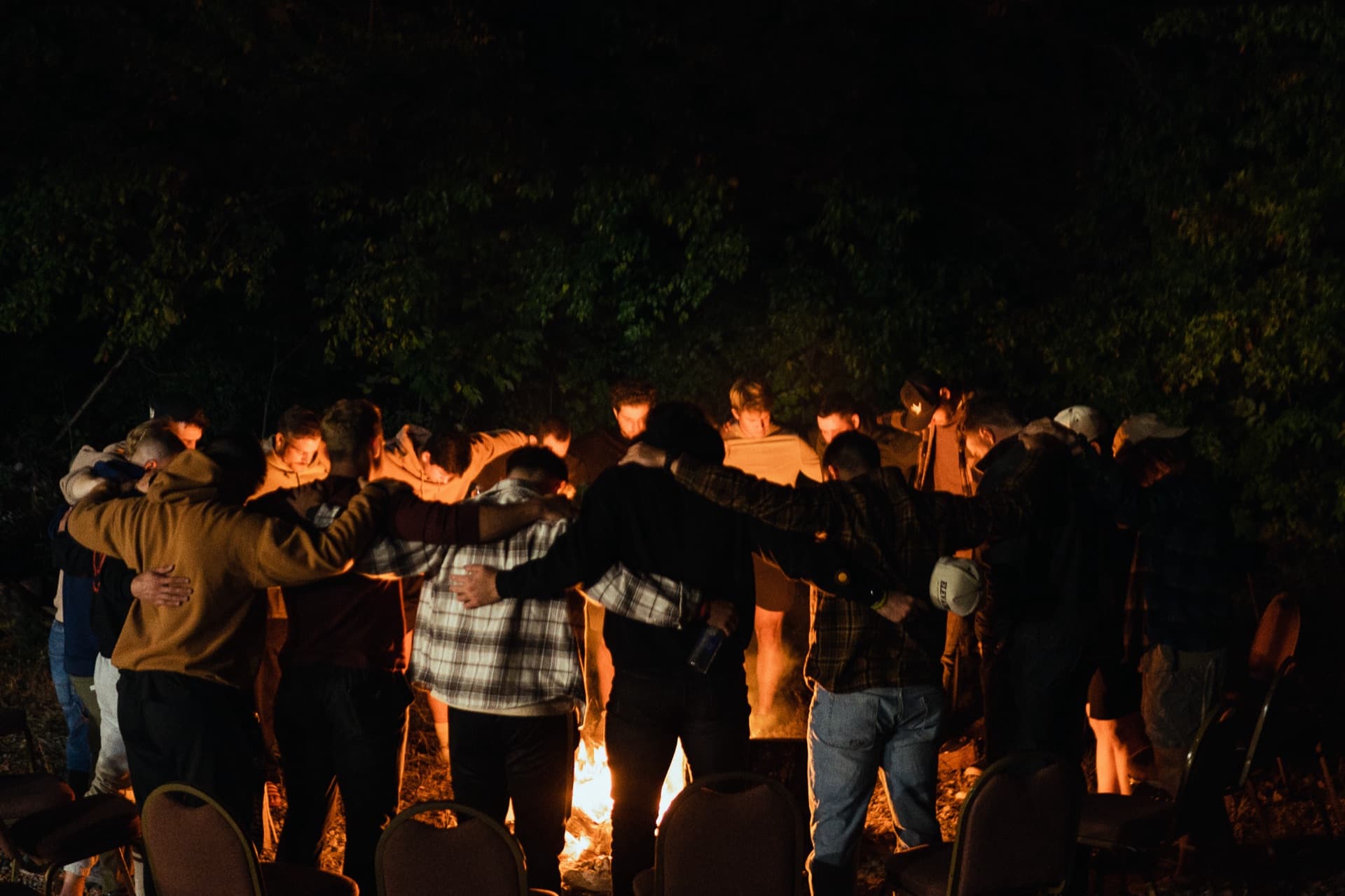 Community praying together around a campfire